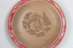 A shallow plate made from Sycamore, it measured 160 mm in diameter by 30 mm deep, Red and White Pebeo paint was used for the rim and a laser for the engraving inside.